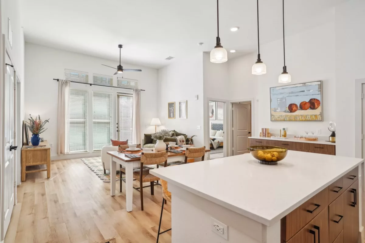 Kitchen with white and brown cabinets, center island, and hanging pendant lights