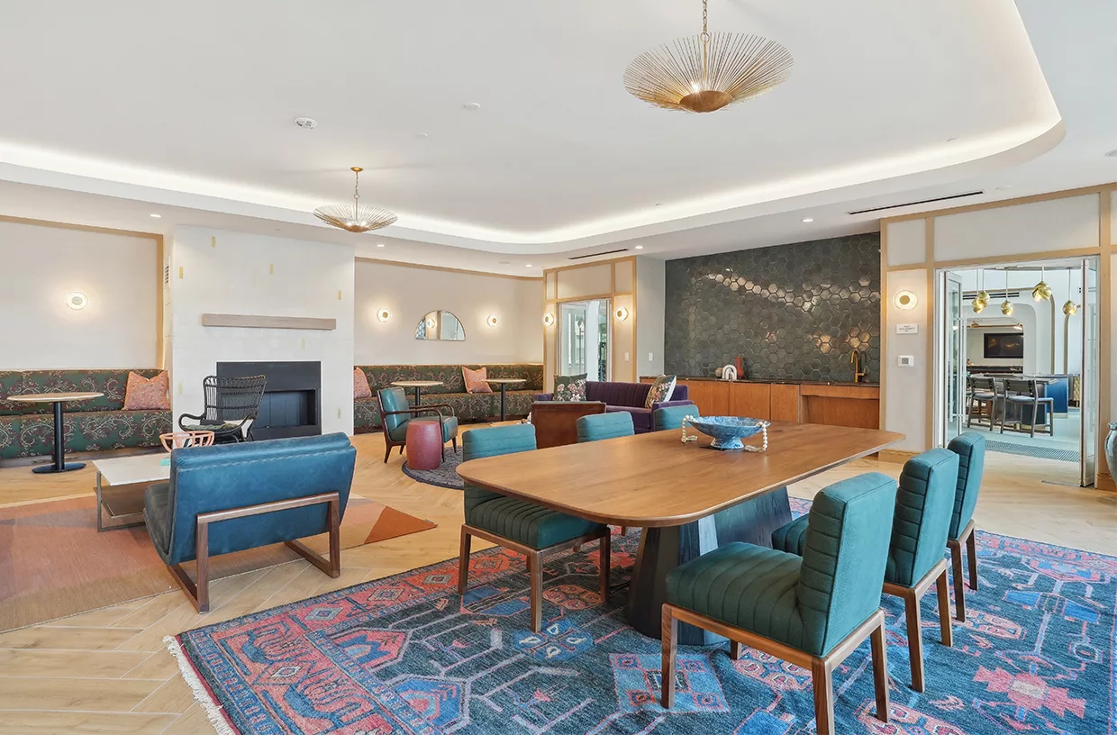 Resident lounge with tables, chairs, and fireplace